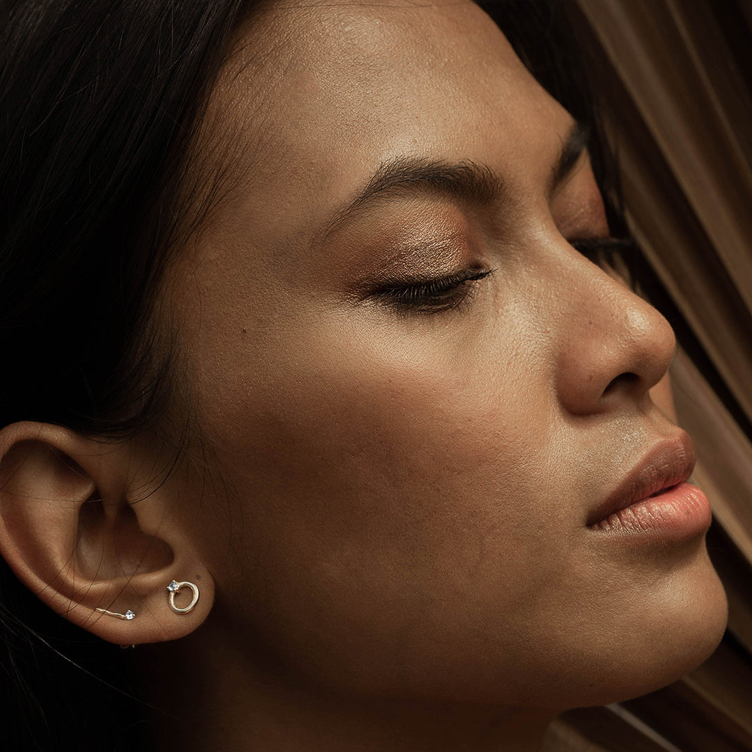 A woman wearing jumna studs and tage studs on the right ear