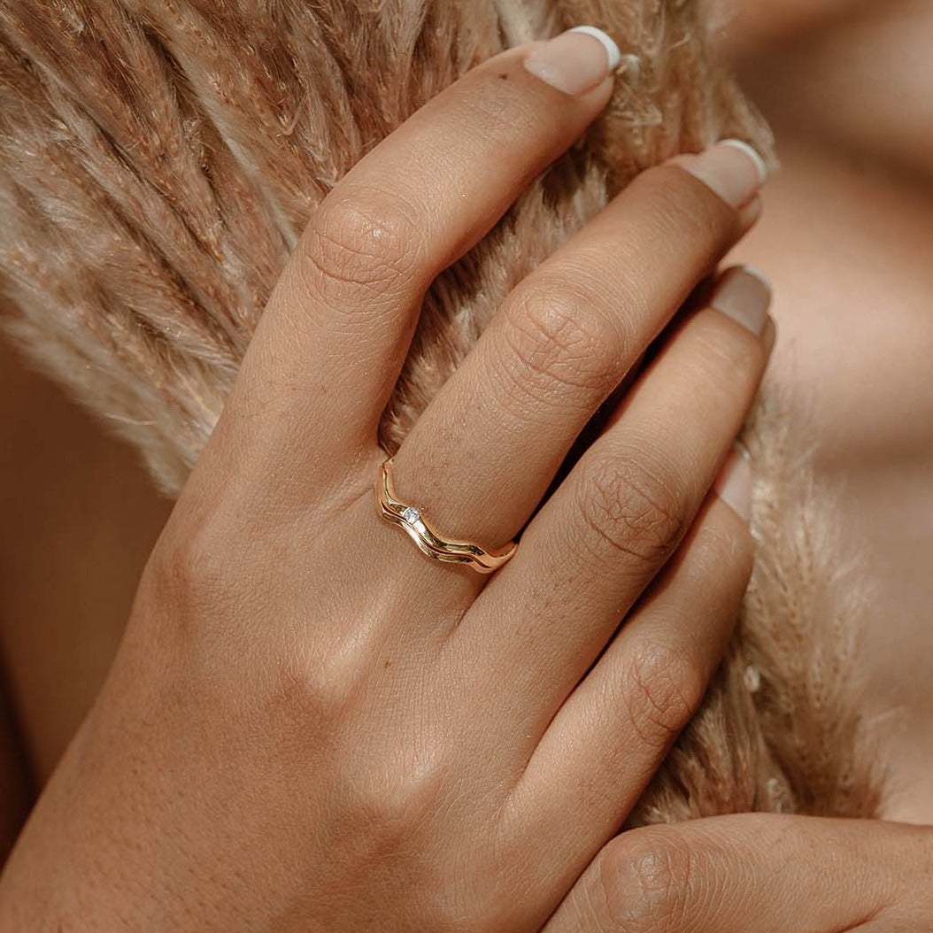 A woman wearing 2 anadyr rings that are stacked together