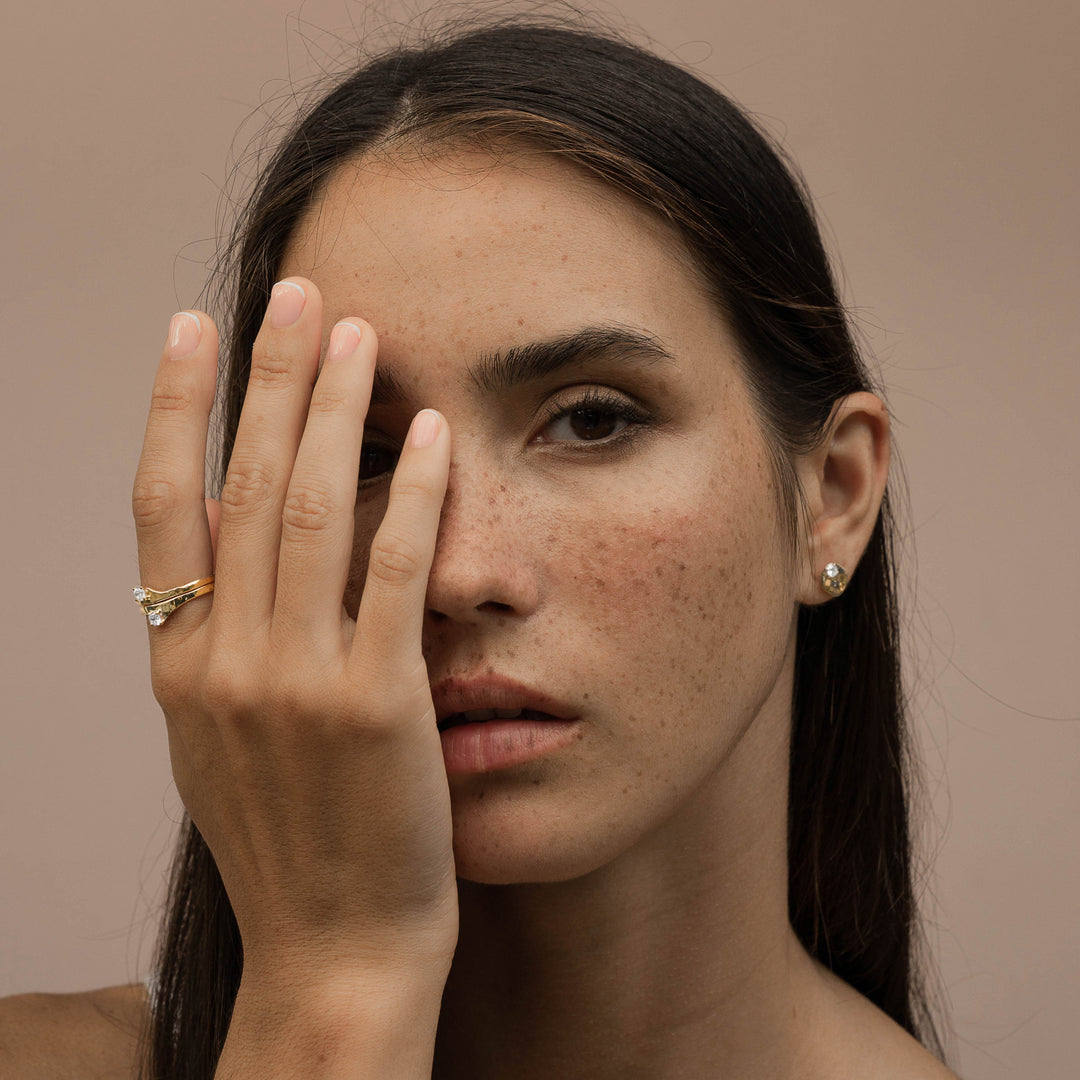 A woman wearing Sceona jewellery set of Ienissei recycled gold rings and Salouen recycled gold earrings