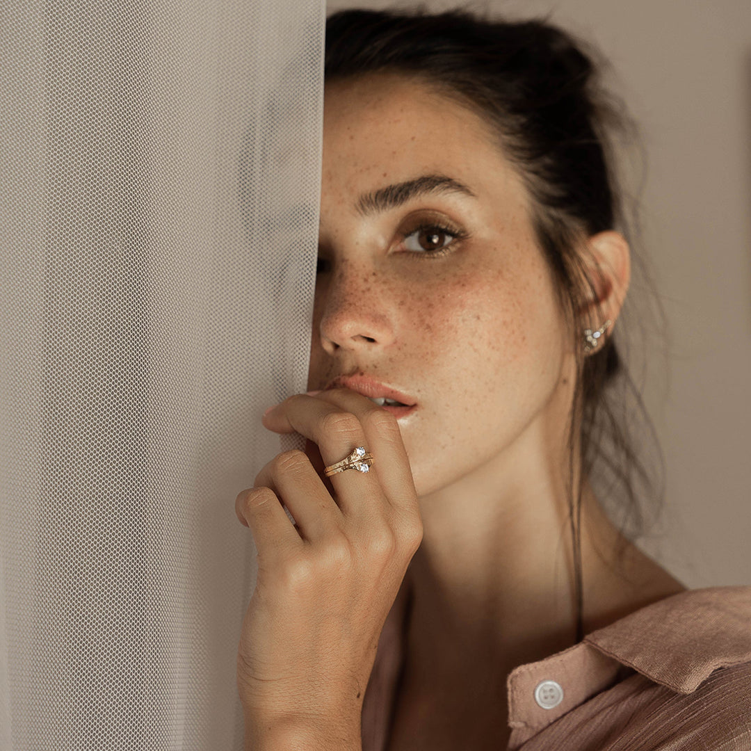 A woman wearing 2 Ienissei rings by ScÃ©ona fine jewellery stacked together on her left hand